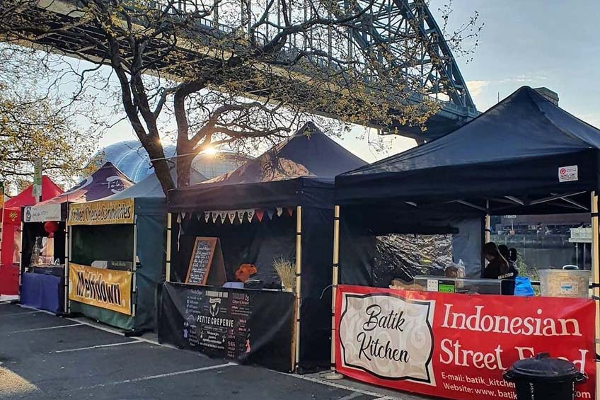 Market stalls in the sun under Tyne Bridge