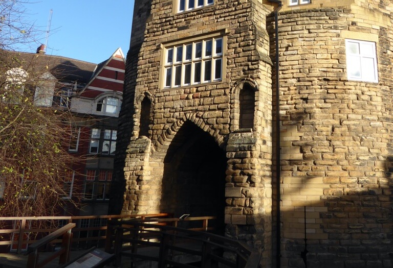 The wooden entrance to Black Gate, an imposing stone gatehouse.